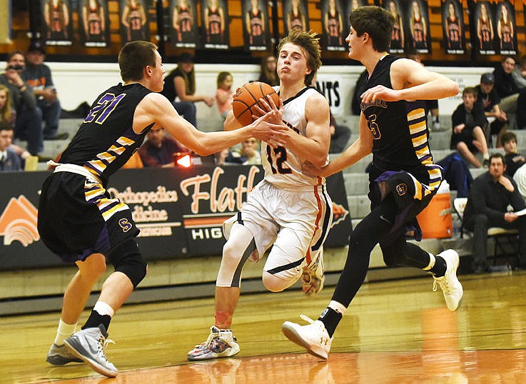 &lt;p&gt;Flathead's Kye AuClaire splits Missoula Sentinel defenders Mitch Reynolds (21) and Sam Beighle (5) as he drives to the basket at Flathead on Thursday. (Aaric Bryan/Daily Inter Lake)&lt;/p&gt;