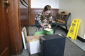 Terry Leonard's wife, Emily, checks the serial numbers of seized computers, an audio recorder and electronic storage devices before signing off on their return Thursday. The Sheriff's Office returned all but one of Leonard's items to her amid an ongoing investigation.