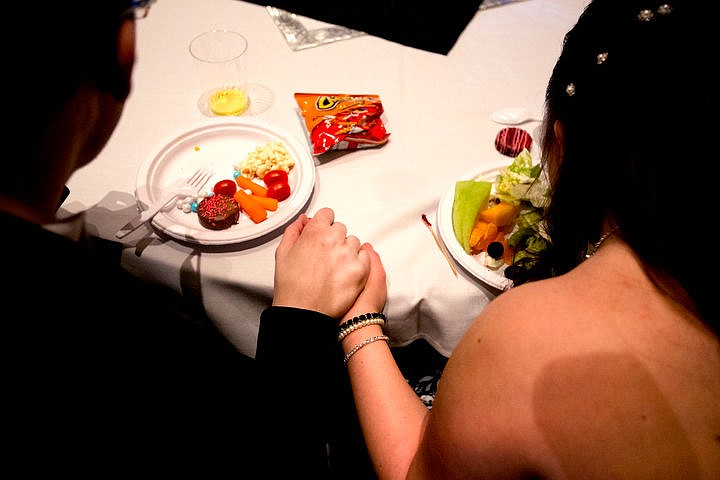 &lt;p&gt;Tevor Kirsebom and his prom date Nikki Cotter hold hands while eating snacks at the Night to Shine prom on Friday, Feb. 12, 2016 at Real Life Ministries in Post Falls. Sponsored by the Tim Tebow Foundation, Night to Shine prom is an annual dance for people with physical and mental disabilities, and is held in hundreds of locations throughout the county.&lt;/p&gt;