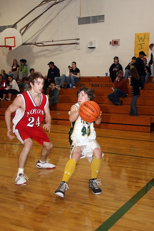 St. Regis Tiger Zane Worral passes the ball during a match against th Noxon Red Devils Saturday night. The Noxon Red Devils won the close 45-38 game after a tough fourth quarter.