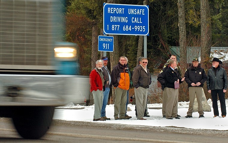 Montana Department of Transportation Director Jim Lynch talks to the media while members of the Montana Motor Carriers Association, area law enforcement and local residents watch a northbound truck on Montana 35 near Bigfork Wednesday morning. The new Highway Watch Program is asking citizens to report unsafe driving behavior as a means to increase safe driving along the highway.