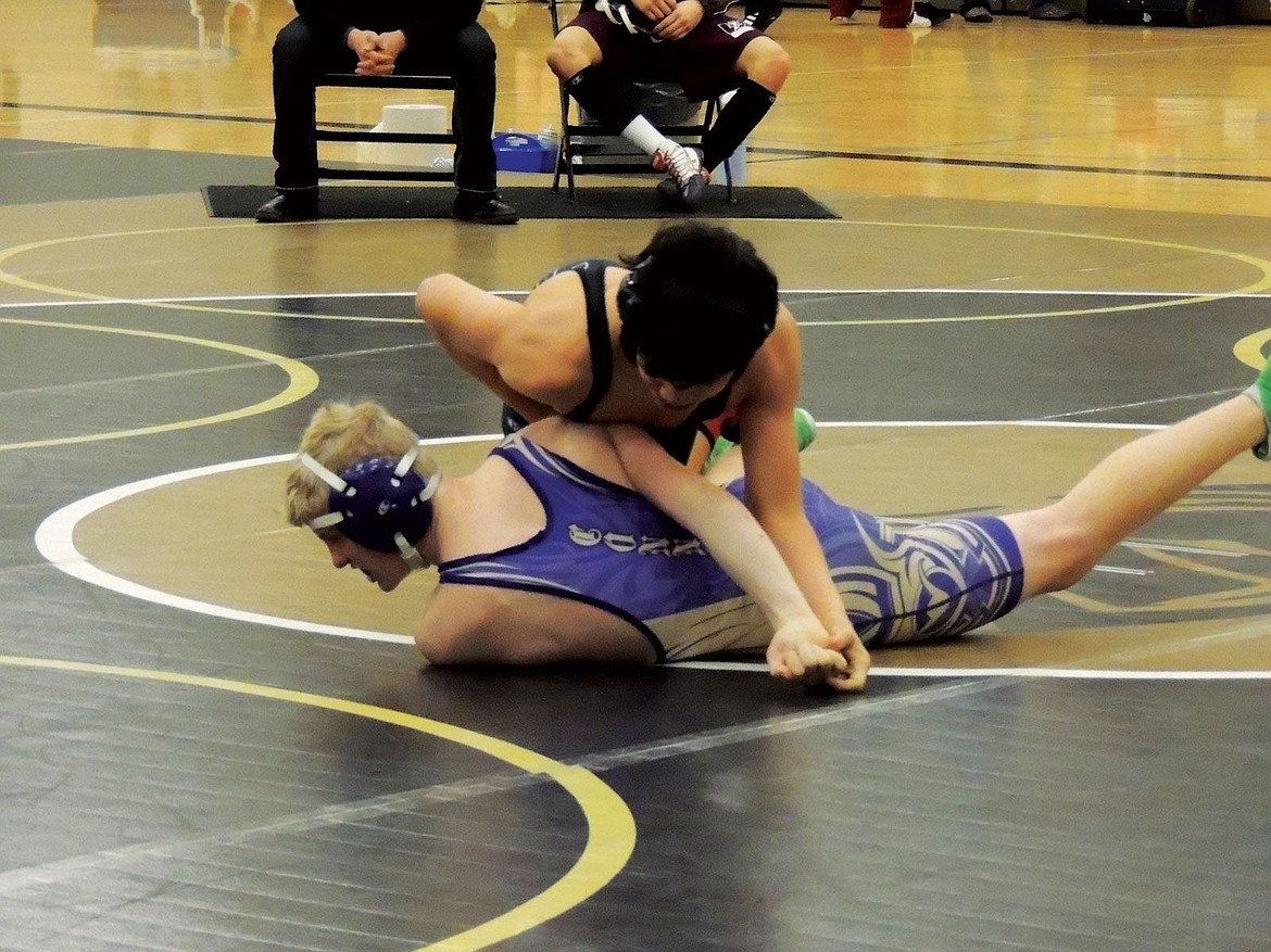 Christopher Lara starts to roll a boy from Connell onto his back for a pin during the first round. He finished second and advanced to regionals.