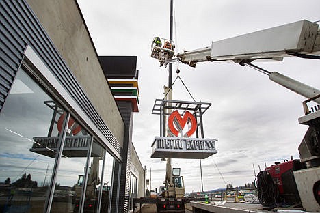 &lt;p&gt;Matt Laufenberg of Strate Line Crane and Rigging, hoists the 6,000 pound Metro Express sign in the air while Joe Laufenberg stands below to steady it with a rope on Thursday morning in Coeur d'Alene.&lt;/p&gt;