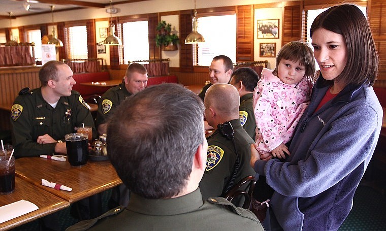 Jennifer Belston talks with Sgt. Steve Lavin, the Kalispell coordinator for the Montana Hope Project, while holding Tasha at a party at Pizza Hut in Kalispell on Wednesday afternoon. Montana Hope Project, which is funded by Montana Highway Patrol troopers, is sending the family to Disney World.