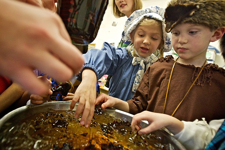 &lt;p&gt;JEROME A. POLLOS/Press Jenessa Norcini and Luke Roberts wait for a batch of homemade molasses candy to harden over ice Friday during a classroom party to celebrate their curriculum covering homestead life in the late-1800's after reading &quot;Little House in the Big Woods&quot; in the second-grade class at Classical Christian Academy in Post Falls. The class made their own butter, smoked meats and taste tested cheese curds.&lt;/p&gt;