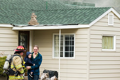 &lt;p&gt;An emotional Serena Harrison is comforted by a firefighter with the Coeur d'Alene Fire Department while holding her son Owen, 1, Thursday in front of her home that smolders in the background.&lt;/p&gt;