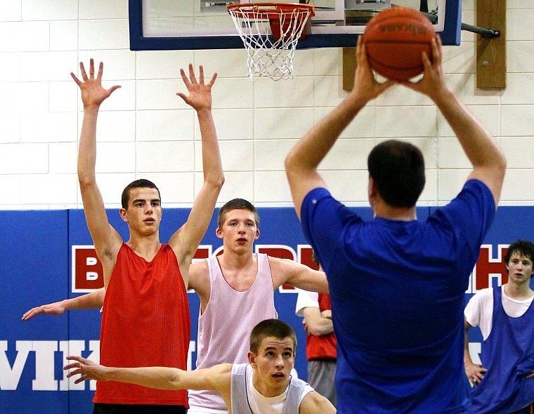 Bigfork Boys Basketball Coach Paul La Mott prepares to make a pass while players Jackson Boese (red) Evan Jordt (front), and Lael Richmond (behind Boese) keep their focus on the ball during practice Tuesday afternoon.