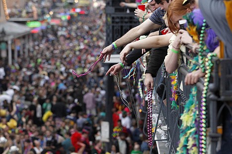 &lt;p&gt;Revelers throw beads from the balcony of the Royal Sonesta Hotel onto crowds on Bourbon Street during Mardi Gras Day festivities in the French Quarter on Mardi Gras day in New Orleans on March 8, 2011. For hours before a parade of glittering floats rolls down stately St. Charles Avenue, Carnival watchers are hard at work.&lt;/p&gt;