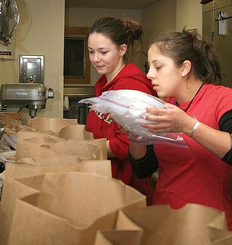 Photo by Nick Ianniello&lt;br&gt;St. Regis seniors Ryanne Burklund (right) and Tailor Davis package cafeteria leftovers for local senior citizens. Burklund and Davis deliver food to six area senior citizens every Monday night through a program they created called Supper for Seniors.