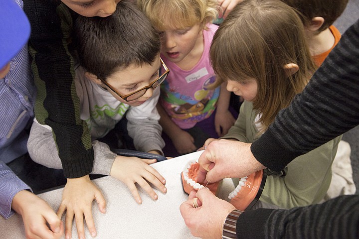 &lt;p&gt;Students in Kim Bennett's class crowd around a table to watch
Dr. Cameron Clark demonstrate how to properly floss teeth.&lt;/p&gt;