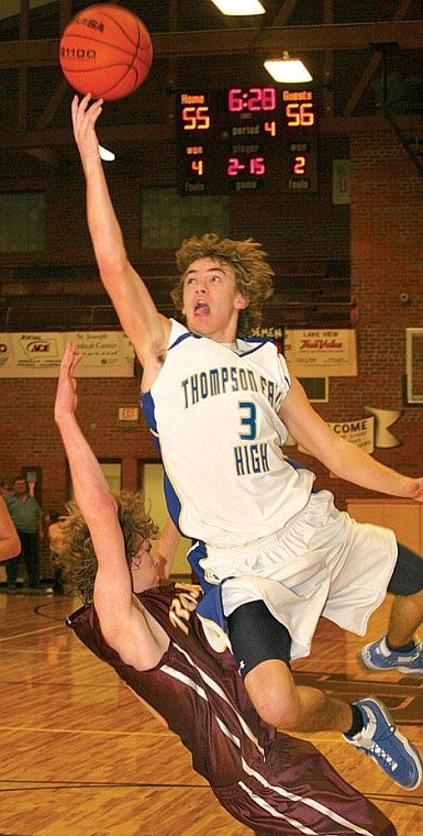 Photo by Ed Moreth&lt;br&gt;Bluehawk Brandon Damaskos leaps over Troy Trojan Delsey Olds at the 8-B District Basketball championship game. Thompson Falls won 66-64.