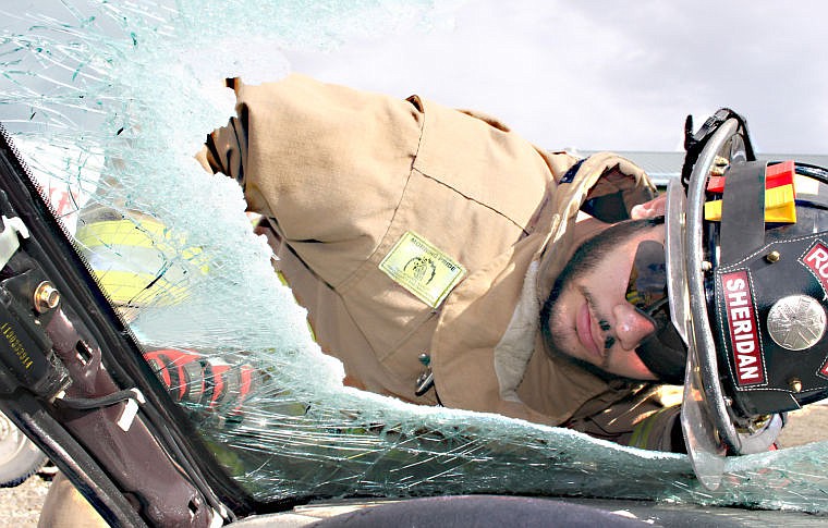 &lt;p&gt;Taking a look inside: Firefighter Trevor Sheridan looks through the broken windshield to ensure everything is going as planned.&lt;/p&gt;