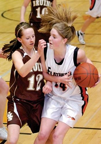 Flathead Bravettes senior forward Ariel Johnson keeps Helena Capital guard Caity Pilgeram (12) at bay during the first half of Friday's game at Flathead. Allison Money/Daily Inter Lake