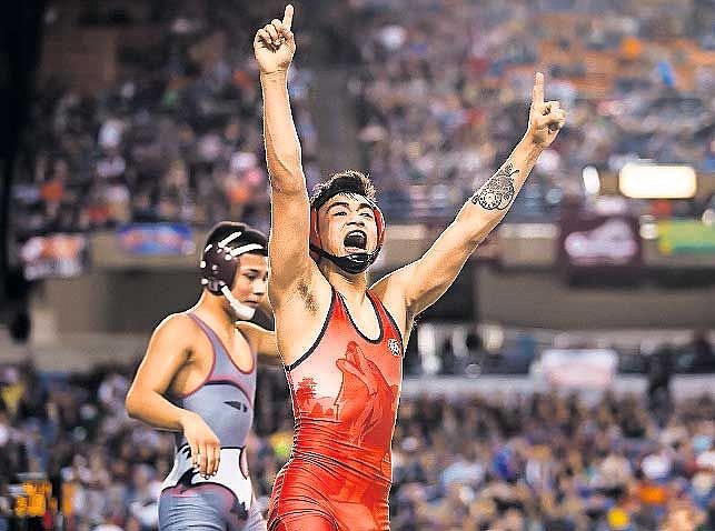 Othellow's Alejandro Cardenas (red) celebrates after winning the Class 2A 126-pound state championship.