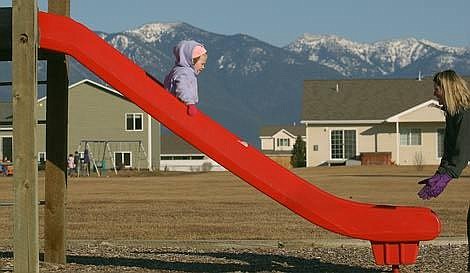 Karen Nichols/Daily Inter Lake&lt;br&gt;Subdivision developers are required by Flathead County to dedicate parkland within the development or to pay cash in-lieu of parkland. At Flathead County's Camelot Park, Regin Koester, 3, enjoys a ride down the slide Monday afternoon. Camelot Park is one of 96 park areas in the county. However, only 35 of those 96 are fully developed because the parks department doesn't have the money to maintain and upgrade all of the property.