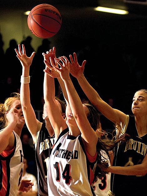 Flathead senior Lindsay Ingram (14) reaches for a rebound between Helena Capital defenders Thursday night in Kalispell. Flathead won, 66-57. Jennifer DeMonte/Daily Inter Lake