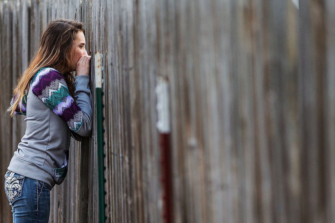 &lt;p&gt;Shantal Baxa looks through an opening in the fence as firefighters work on the scene of her family&#146;s home.&lt;/p&gt;