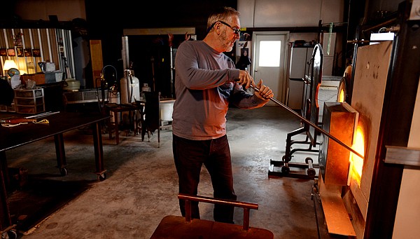 <p>Lee Proctor gathers a glob of molten glass from the furnace in his studio as he begins the process of blowing a glass bulb on Friday, February 15, at his studio in Bigfork. Proctor is currently working on a number of pieces for the upcoming Of the Earth display which will be on display at the Hockaday Museum from late February to mid-April. Of the Earth will feature work from 11 artists and the opening reception, which is free and open to the public, will be held on Thursday, February 28 from 5-7 p.m. (Brenda Ahearn/Daily Inter Lake)</p>