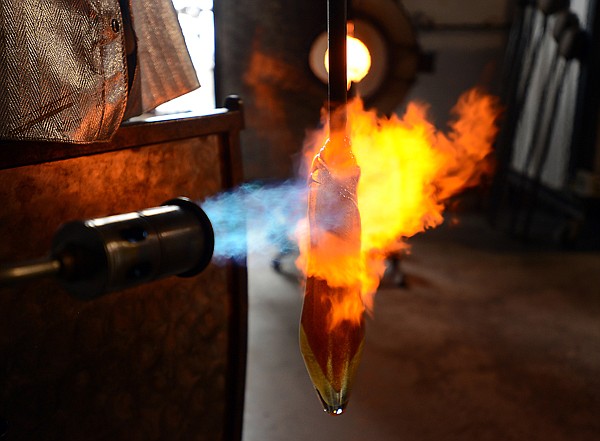 <p>Lee Proctor uses a torch and the force of gravity to make the final adjustments to the shape of a bulb he has blown on Friday, February 15, at his studio in Bigfork. (Brenda Ahearn/Daily Inter Lake)</p>