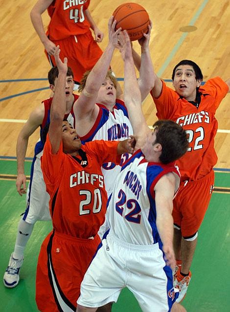 Columbia Falls&#146; Mackey Nolan (22) and teammate Chase Grilley battle for a rebound against Ronan&#146;s Makenzy Kelch (20) and Jordan St. Clair during a semifinal game at the Northwestern A divisional boys&#146; basketball tournament at Glacier High School on Friday night. Ronan won in overtime. Garrett Cheen/Daily Inter Lake