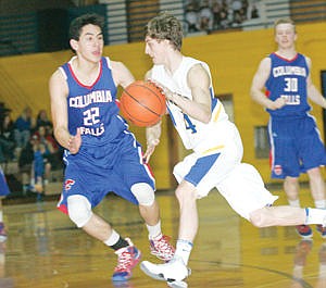 <p>Senior guard Luke Adamson drives the lane with Tyler Murphy in tow second quarter vs. Columbia Falls 2-21-15.</p>