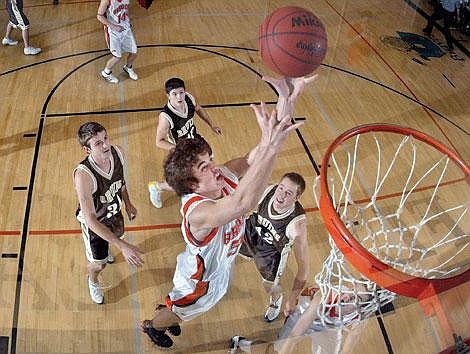 Flathead&#146;s Brock Osweiler pulls down a rebound between Helena Capital&#146;s Brian Nickel (34), Marcus Rowan and Clay Bignell (42) during the first half of Thursday night&#146;s game at Flathead High School. Osweiler finished with the game with seven points, seven rebounds and four blocked shots in the Braves&#146; 48-46 victory over the Bruins. Craig Moore/Daily Inter Lake