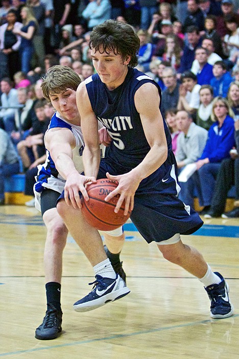 <p>Lake City High's Justin Pratt drives through the outreached arm of Joe Roletto from Coeur d'Alene High during the first half.</p>