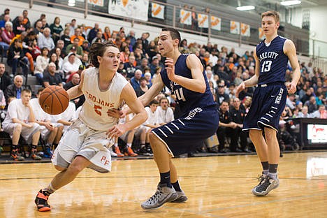 &lt;p&gt;Max McCullough of Post Falls High, drives passed Lake City's Joe Pasquale at the 5A Region 1 District Tournament Championship game on Tuesday at The Arena.&lt;/p&gt;