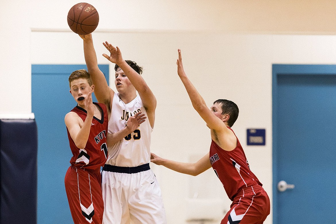 &lt;p&gt;SHAWN GUST/Press Genesis Prep Academy&#146;s Caleb Symons passes the ball under pressure from Kootenai High&#146;s Kaden Hammond, left, and Hunter Whipple during the first quarter.&lt;/p&gt;