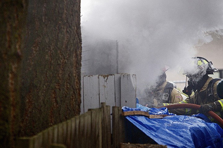 &lt;p&gt;JEROME A. POLLOS/Press Coeur d'Alene firefighters spray the interior of a small trailer with water Friday as smoke billows out of the doorway on the 700-block of Spruce Avenue in Coeur d'Alene. Firefighters were able to contain the fire to the trailer. A cause has yet to be determined as the fire is still under investigation.&lt;/p&gt;