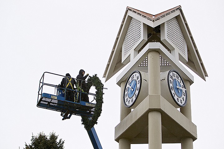 &lt;p&gt;JEROME A. POLLOS/Press J.R. Harmon, right, secures a large wreath into position Thursday after removing the decoration from the clock tower in downtown Coeur d'Alene.&lt;/p&gt;