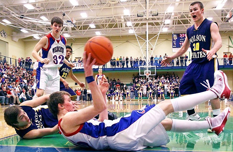 Columbia Falls' Kaleb Johnson looks for an open teammate from the baseline after diving to the floor for a loose ball during the championship game of the Northwestern A divisional tournament Saturday evening at Glacier High School.