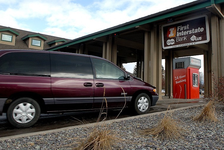 A customer goes into the drive-through at First Interstate Bank in Evergreen Thursday afternoon. The Evergreen facility is one of 72 banks in the First Interstate operation. The bank firm has proposed a public stock sale this summer.