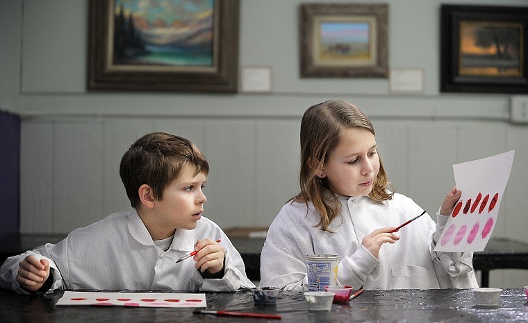 Isabel Larscheid, 11, shows her brother Kevin, 9, both of Kalispell, how she has begun to work create  tints and shades of red by adding white or black paint on Wednesday at the Home School Art Class at the Hockaday Museum on Wednesday in Kalispell. Home School art classes are available every Wednesday from 1030 to noon.