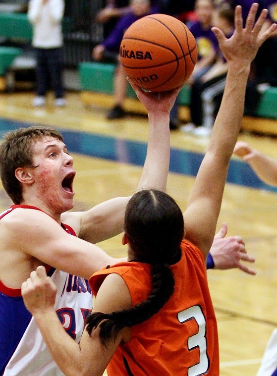 Nate Chute/Daily Inter Lake
Kaleb Johnson drives into the lane to lift up a shot over Ronan's Jerod Tanner.