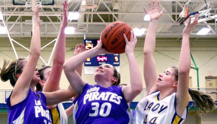 Polson's Riley Kenney gets set to put a rebounded ball back up for a shot in the fourth quarter while surrounded by teammate Breanne Kelley and Libby's Jackie Mee (back) and Kim Tangen in the semifinal of the Northwestern A divisional basketball tournament at Glacier High School Friday afternoon.