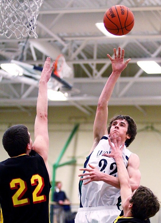 Glacier's Logan Quay lets a shot sail over Missoula Hellgate's Dan Clucas (22) and Ben Hartmann during Tuesday evening's game in Kalispell.