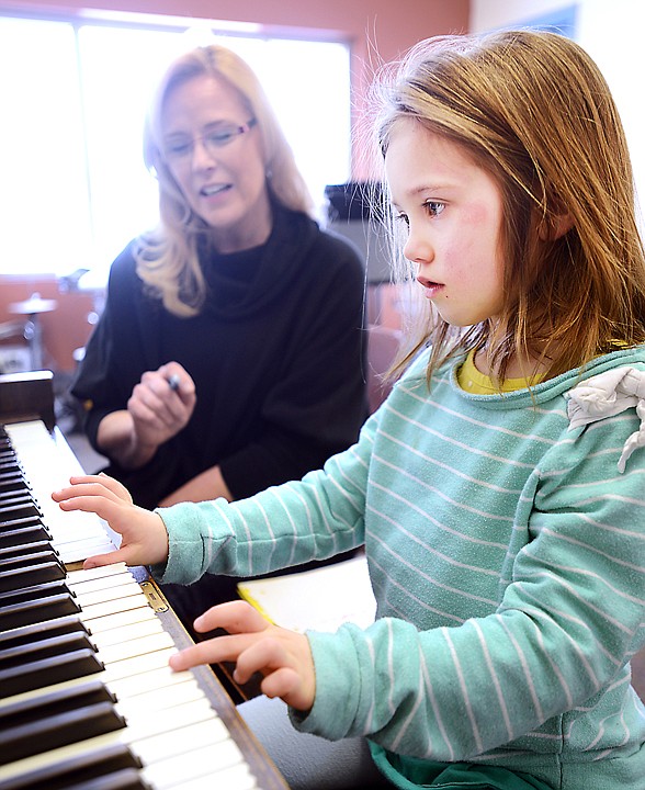 <p>Music teacher Marcy Holston works Wednesday with elementary I student Ava Bessen at Kalispell Montessori.</p>
