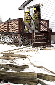 From left, Zoe Banovitch and Lt. Marlin Cooper came out of the house as others went inside to investigate the fire's cause.