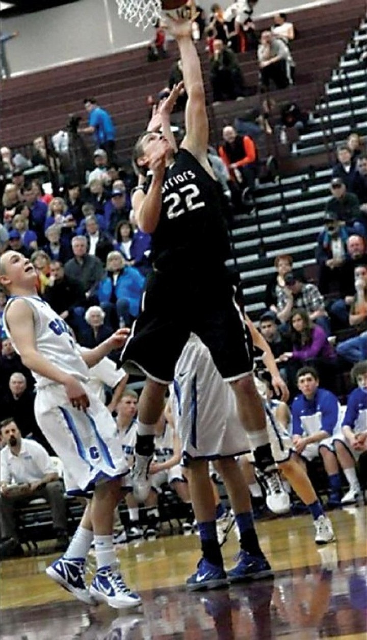 The Warriors Jake Johnason kisses the ball off the glass for two points in the game against the No. 1 ranked Wildcats.