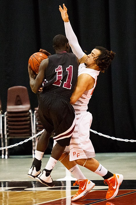 <p>The Trojans' Marcus Colbert provides defense for Post Falls during state basketball play against Centennial.</p>