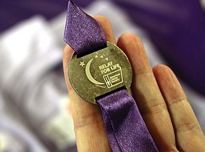 Debbi Kirschbaum, the Plains Woman's Club Relay for Life team captain, holds last year's relay medal at the Relay for Life kick-off event on Sunday afternoon at the Senior Citizen Center in Plains.