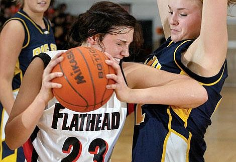 Flathead&#146;s Sara Newgard (23) holds her ground after pulling down a rebound over Big Sky&#146;s Lacey Phelan during the second half of Thursday night&#146;s Western AA playoff game at Flathead High School. The Bravettes defeated the Missoula Big Sky Eagles, 59-42. Craig Moore/Daily Inter Lake