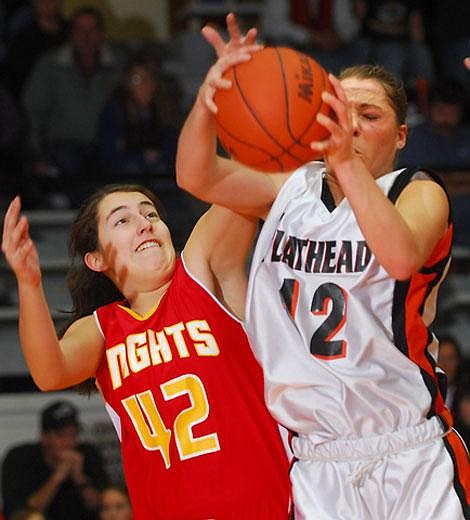 Flathead senior guard Kendalyn Habel (12) steals an offensive rebound away from Missoula Hellgate&#146;s Kaitlyn Horner (42) after a missed free throw during second-quarter action Saturday in a Western AA girls&#146; basketball playoff game at Flathead. Habel finished with 18 points to lead the Bravettes offensively.