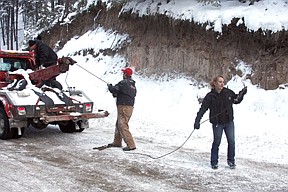 From left, Nate Crowley, Duane Ovitt, and Becca Ovitt, of the Valley Towing wreck recovery team in Plains gets ready to recover Deputy Steven Spurr's totaled SUV on last Thursday evening.  The recovery took about three hours, two wrecker trucks and five people to get it out of the steep ditch.