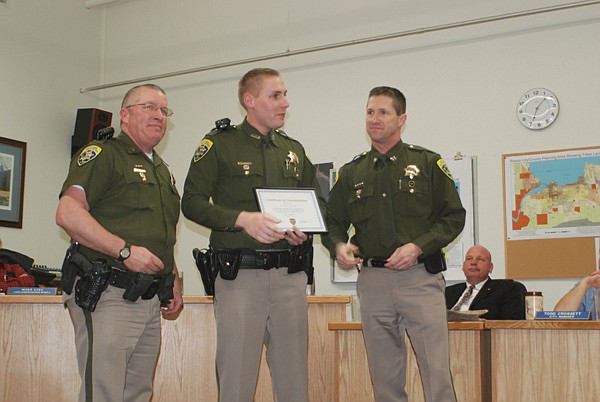 MHP Trooper Tim Procter, middle, displays his award on Monday. He was awarded a Certificate of Merit on Monday.