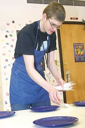 Canda Harbaugh/The Western News Junior Andy Simonis, prepares a lunch table for Kootenai Valley Head Start students as part of a new job training class offered at Libby High School.