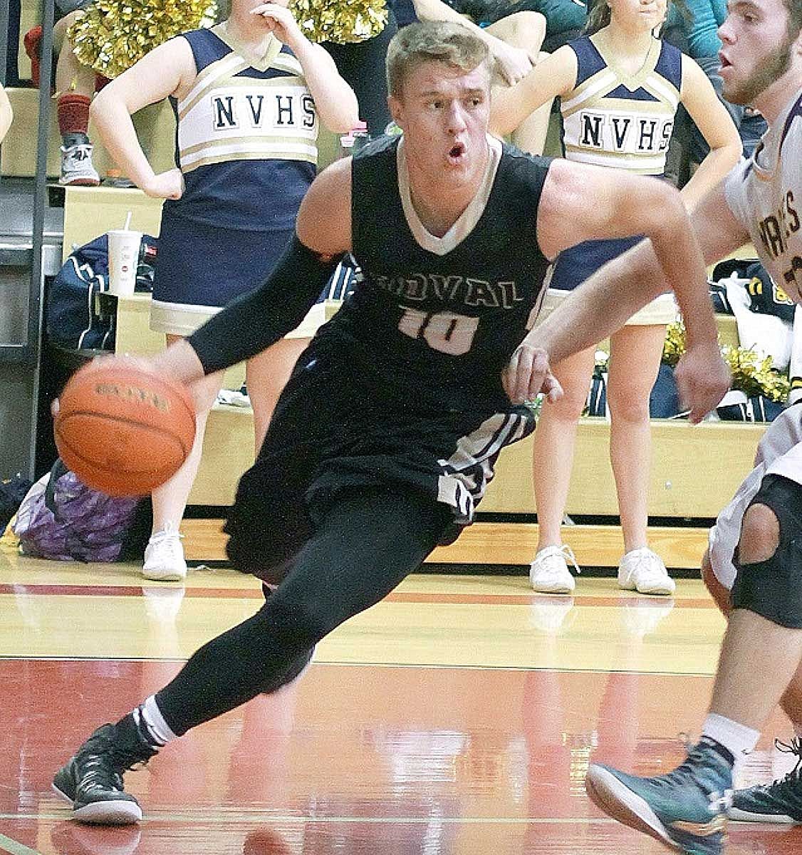 Junior workhorse Kaden Jenks drives around two Naches defenders for two of his team-leading 24 points.