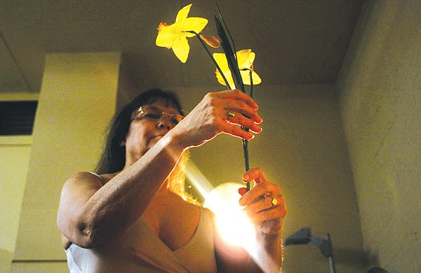 Figure drawing model Susan Evans holds a prop flower during a workshop Saturday at the new Sandpiper Gallery workroom.