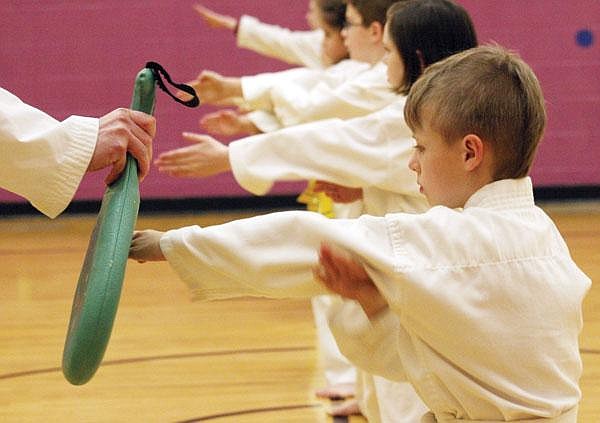 Canda Harbaugh/The Western News Bleyz Lorengo, 8, performs a block during his Tae Kwon Do belt test last week at the McGrade Center gym. Lorengo's mom and grandma also attend Libby Dae Myung School.